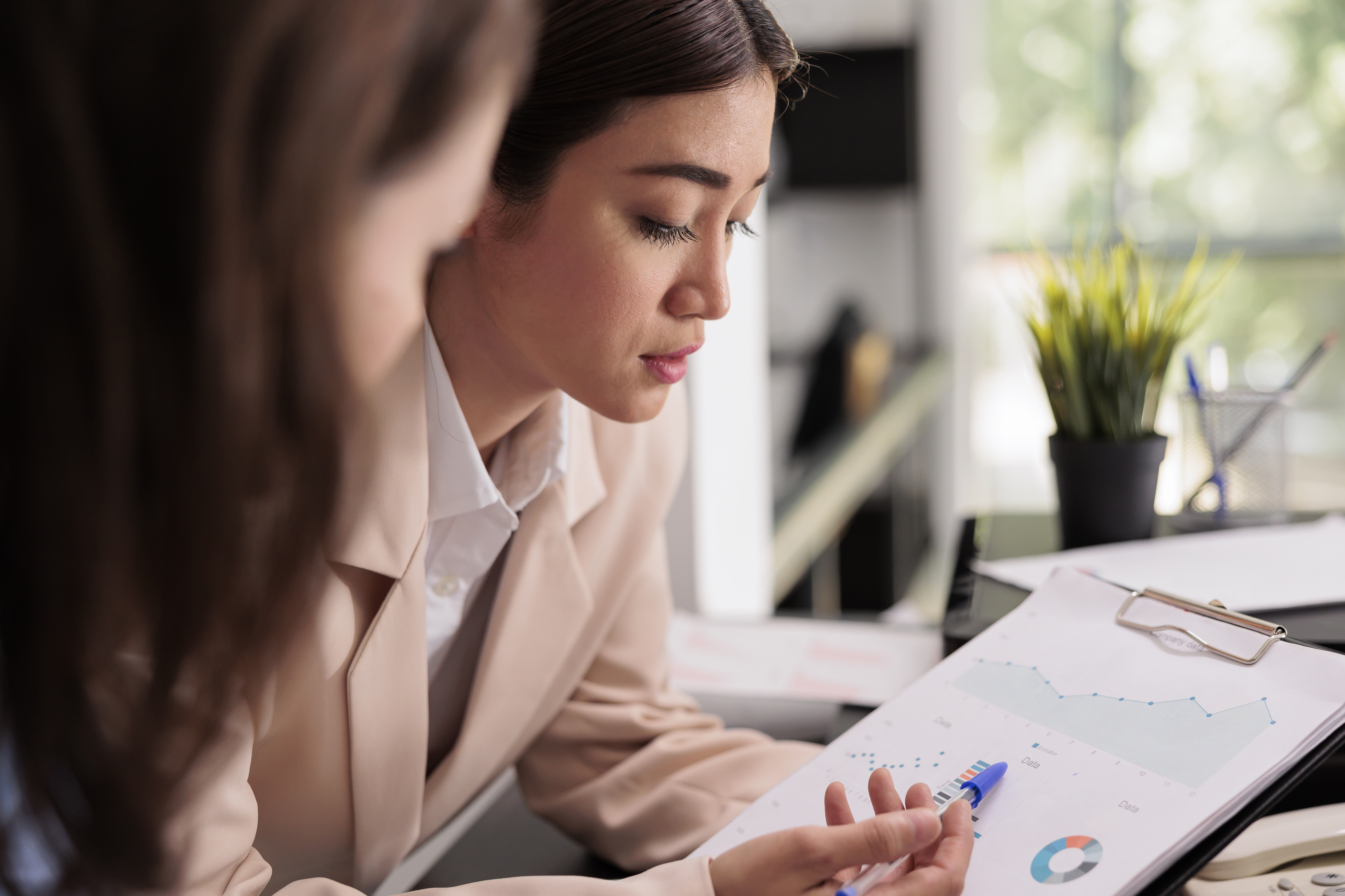 Employees analyzing financial report statistics on clipboard